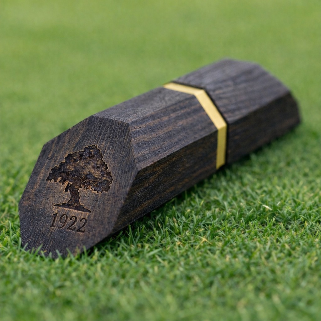 Dark walnut hexagonal tee marker with gold brass inlay stripe, engraved tree logo and 1922 date mark.